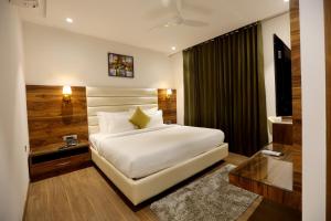 KarnalROYAL LALIT Grand Hotel的房间里有一张白色大床的卧室