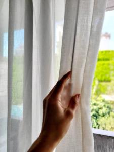 a person opening a white window with their hand at Moderno Departamento en Zona de Vanguardia in Buenos Aires