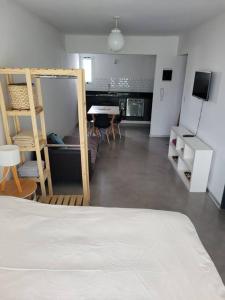 a bedroom with a bed and a kitchen with a table at Moderno Departamento en Zona de Vanguardia in Buenos Aires