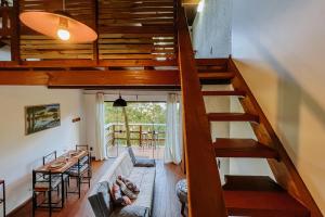 een trap in een woonkamer met een bank en een tafel bij Vista para o Mar Dunas e Lagoa em Garopaba in Garopaba