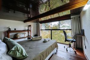 ガロパバにあるVista para o Mar Dunas e Lagoa em Garopabaのベッドルーム1室(ベッド1台、大きな窓付)