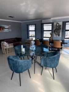 une salle à manger avec une table et des chaises en verre dans l'établissement Mo'Acress Lifestyle, 