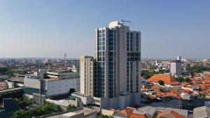 um alto edifício branco no meio de uma cidade em Platinum Hotel Tunjungan Surabaya em Surabaia