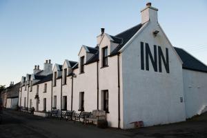 un edificio blanco con las palabras nim en él en An Cala Beag Self Catering apartment on The Waternish Peninsula en Hallin