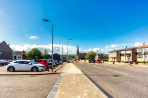 a white car parked on the side of a street at Kali Apartment - Spacious 3 bed apartment in Wishaw in Wishaw