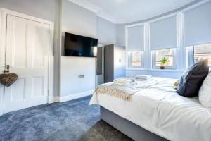 1 dormitorio con 1 cama, TV y ventana en Kali Apartment - Spacious 3 bed apartment in Wishaw, en Wishaw