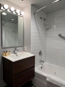 a bathroom with a sink and a tub and a mirror at The Dover House Resort in Delray Beach