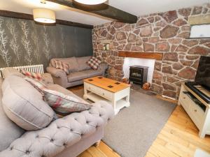 a living room with a couch and a fireplace at Dove Cottage in Abergele