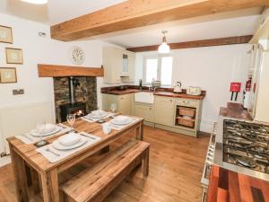 a kitchen with a wooden table and a dining room at Dove Cottage in Abergele