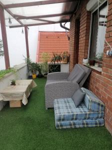 patio z dwoma kanapami i stołem na trawie w obiekcie Újkapu Sunshine Apartments w Győr