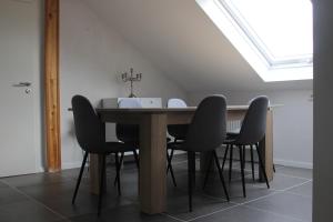 een eettafel met zwarte stoelen en een dakraam bij ALB-Wohnung - Schwäbische Alb in Heroldstatt