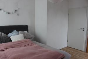 Schlafzimmer mit einem Bett mit einem Spiegel und einer Tür in der Unterkunft ALB-Wohnung - Schwäbische Alb in Heroldstatt
