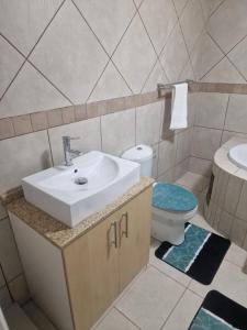 a bathroom with a sink and a toilet at Pinto City Motel in Kempton Park +57 photos