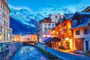 a river in a city with buildings and a bridge at Green Apple Chamonix, centre, parking, ski-in/out in Chamonix-Mont-Blanc