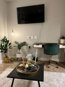 a living room with a table with a tv on the wall at 715 Foreshore Place Luxury Apartment-Cape Town CBD in Cape Town