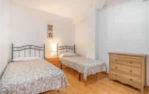 1 dormitorio con 2 camas y tocador de madera en 1 Bedroom Nice Apartment In Santa Pola, en Santa Pola