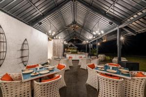 restauracja ze stołami i krzesłami oraz sufitem w obiekcie Canary Islands Resort & Spa w mieście Lonavla