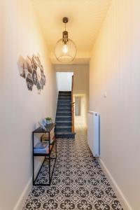 a hallway with a staircase and a floor with tiles at Vakantiewoning Mèzik in Maasmechelen