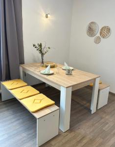 a wooden table with yellow cushions on top of it at AMS Appartement Spaichingen in Spaichingen