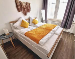 a bedroom with a bed with white and yellow sheets at AMS Appartement Spaichingen in Spaichingen