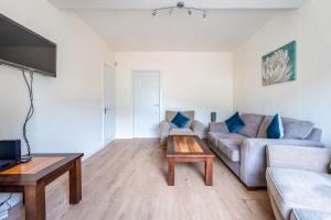 een woonkamer met een bank en een tafel bij Millfield House - Cosy 2 bed house in Motherwell in Motherwell