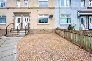 a house with a fence and a driveway at Millfield House - Cosy 2 bed house in Motherwell in Motherwell