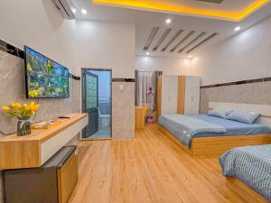 a bedroom with two beds and a television in it at Homestay Qhome in Con Dao