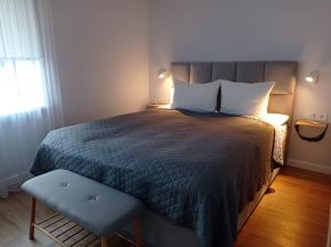 um quarto com uma cama, uma cadeira e uma janela em TIMO butas em Druskininkai