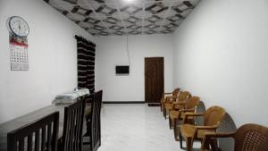 Serene Homestay في أنورادابورا: غرفة صف من الكراسي وساعة على الحائط