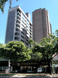 un grand bâtiment avec des arbres devant lui dans l'établissement Boulevard Plaza, à Belo Horizonte