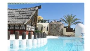 a swimming pool next to a house and a building at VCV VILLA BAHÍA FELIZ in Playa del Aguila