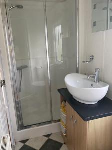 a bathroom with a white sink and a shower at Lili-anns Retreat Cosy Holiday Home in Millom