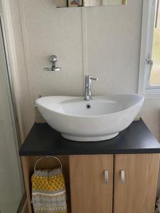 a white sink on a black counter in a bathroom at Lili-anns Retreat Cosy Holiday Home in Millom