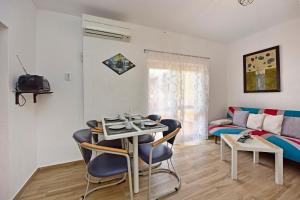 a living room with a table and chairs and a couch at APP Laura with Common Pool in Nova Vas