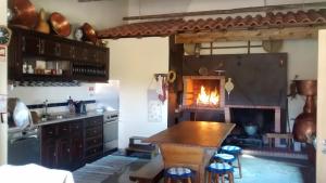 a kitchen with a fireplace and a table and chairs at Casarao dos Reis in Caravela