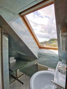 a bathroom with a skylight and a sink and a window at Landrasthaus Maria Bild in Maria Bild