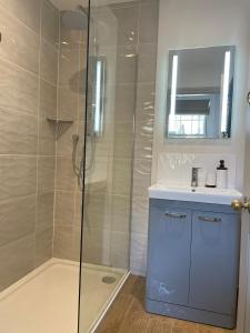 a bathroom with a shower and a sink and a mirror at Rosedene Regency Annex in Minster