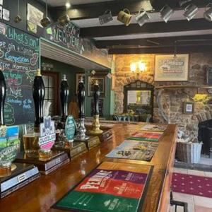 un bar en un restaurante con barra y mostrador en The Countryman’s Inn en Hunton