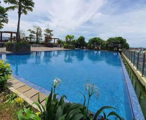 a large swimming pool with blue water at Vidaview Brenstville Tower in Makassar