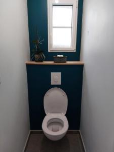 La salle de bains est pourvue de toilettes blanches et d'une fenêtre. dans l'établissement Chambre d’hôte Chancelier Guerin, à Mont-lʼEvêque