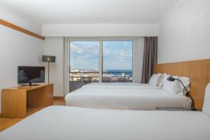 a hotel room with two beds and a television at B&B HOTEL Sado Setúbal in Setúbal