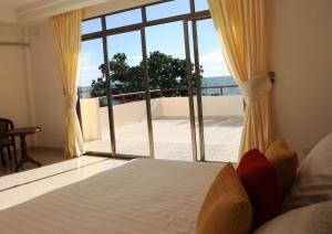 a bedroom with a bed and a large window at Emerald Hotel & Restaurant in Nuku‘alofa
