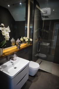 a bathroom with a white sink and a toilet at The Loft at Hewletts Farm - Stunning Apartment on The Cotswold Way Close to Cheltenham in Cheltenham