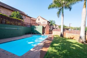 a swimming pool in a yard with palm trees at Bougainvillea 1 in KwaDukuza