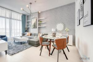 un soggiorno con tavolo e divano di Contemporary 1BR at Prime Views Meydan by Deluxe Holiday Homes a Dubai