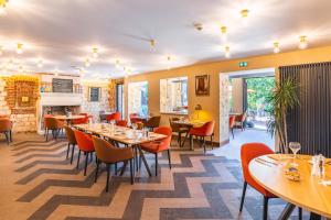 a restaurant with tables and chairs and a fireplace at Logis Hôtel & Restaurant - Les Hauts de Montreuil in Montreuil-sur-Mer