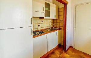 a small kitchen with white cabinets and a sink at San Remo in Lido di Pomposa