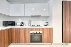Virtuvė arba virtuvėlė apgyvendinimo įstaigoje Contemporary 1BR at Prime Views Meydan by Deluxe Holiday Homes