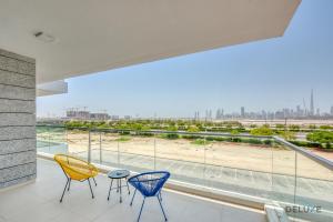 a balcony with chairs and a view of the city at Contemporary 1BR at Prime Views Meydan by Deluxe Holiday Homes in Dubai