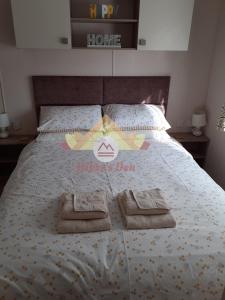 1 dormitorio con 1 cama con 2 toallas en Hiker's Den, Brigham, Cockermouth, Cumbria, en Cockermouth